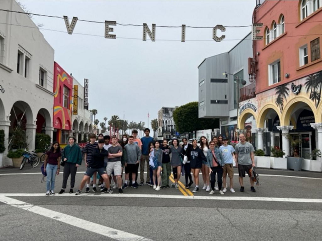 A group of people standing in a street Description automatically generated